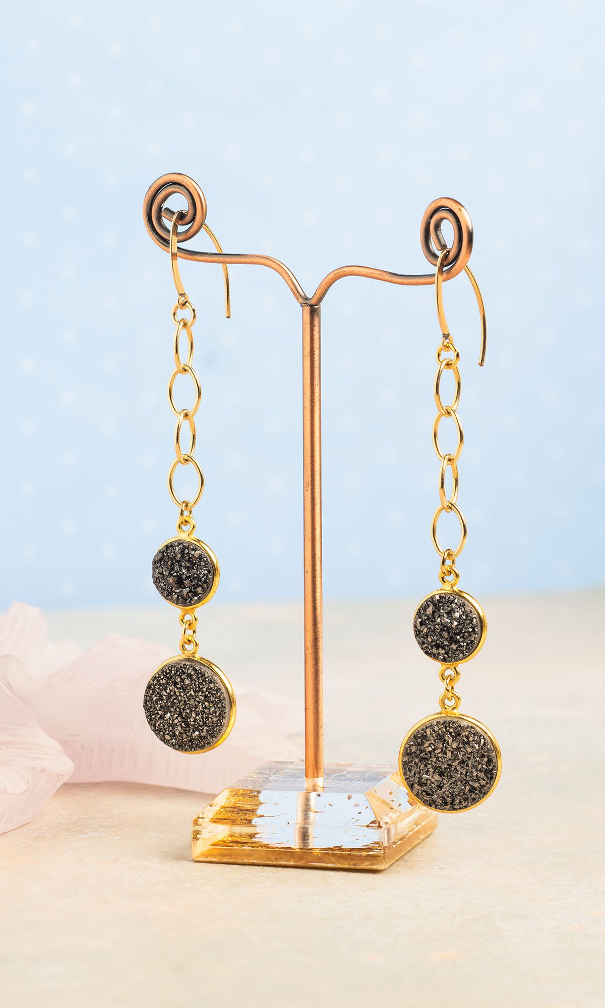 Earrings hanging from brass colored wire tree