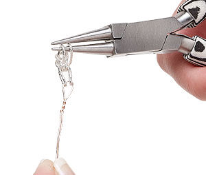 Two links of a chain being held by pliers