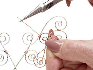 Step 6: Pliers attach spiraling S shapes of wire to one another