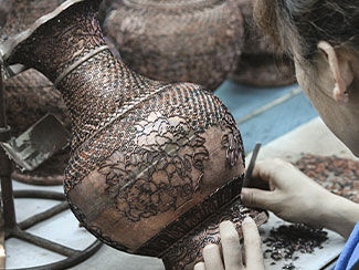 an artist creating wire framework on a vase