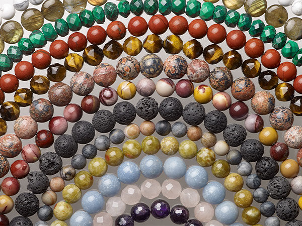 A variety of round gemstone bead strands, both smooth and faceted, in a range of sizes.
