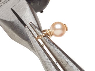 Step 2 showing pliers creating a double wrapped loop on a pearl drop