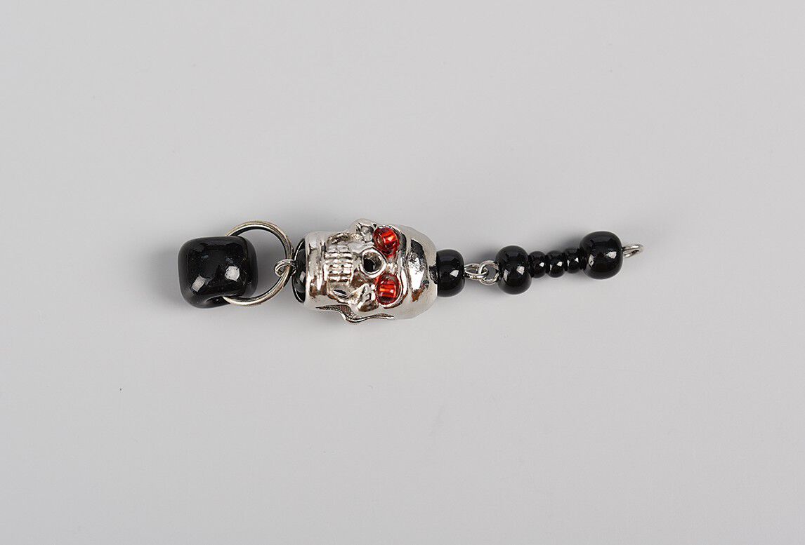 Shortest dangle showing black seed beads and skull bead