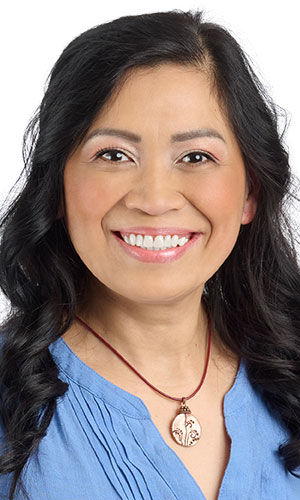 A smiling woman wearing Design Idea R H 2 2