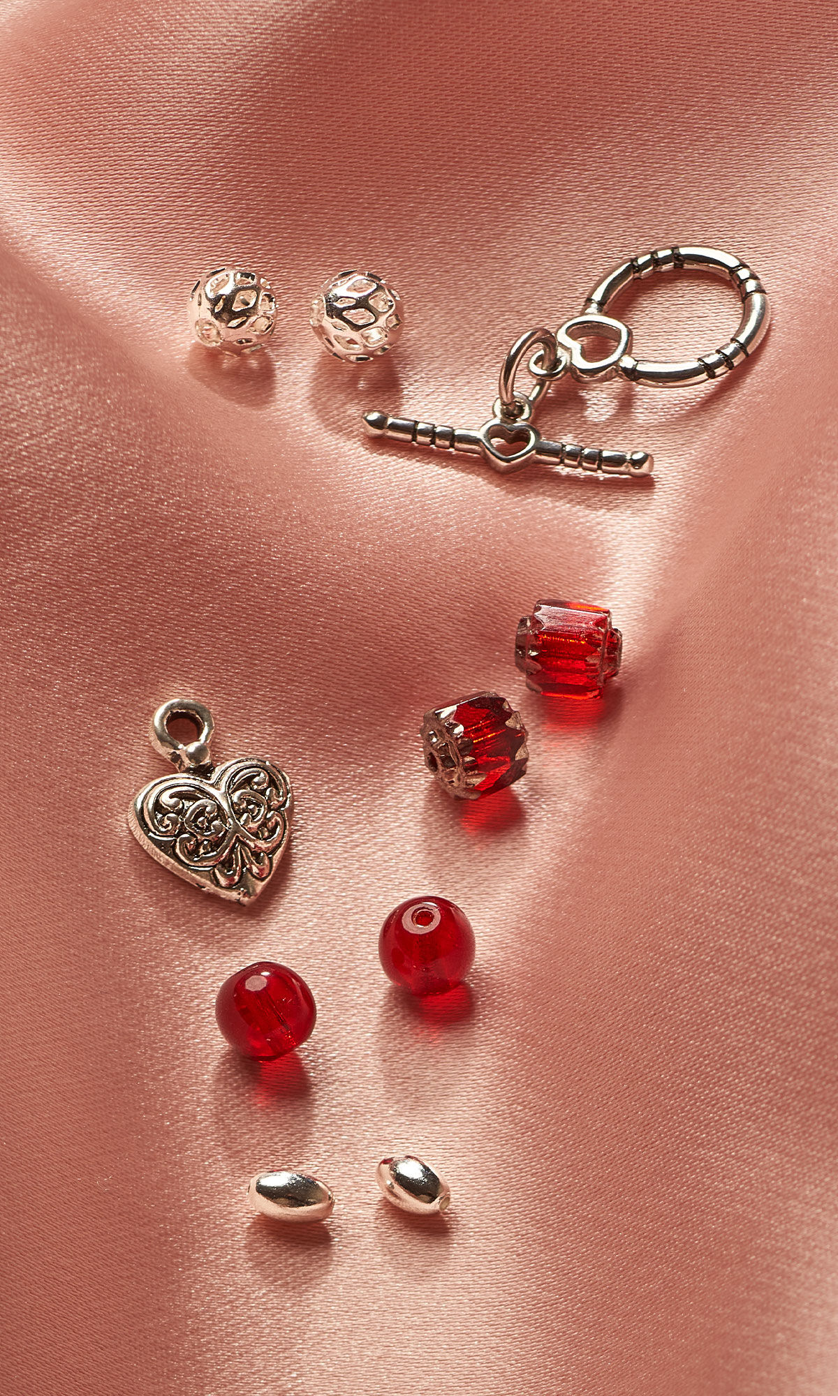 Assorted beads and findings on pink cloth