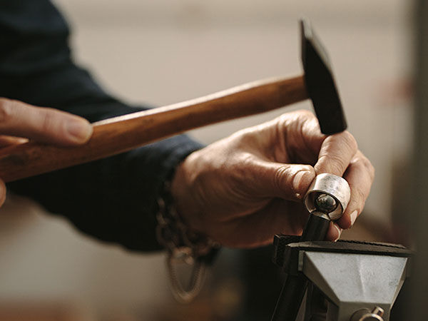 a metalsmith hammering metal