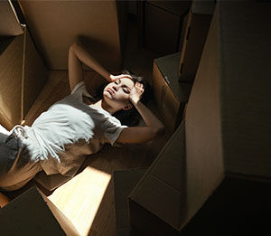 Stressed woman surrounded by cardboard boxes
