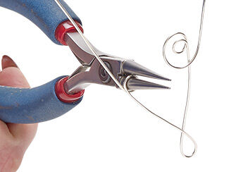Step 3: Silver wire is coiled around chain-nose pliers to create spiraling, swirling shapes