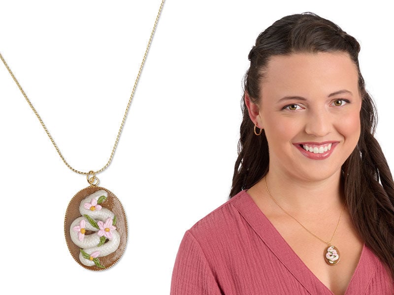A model wearing a chain necklace with a handmade polymer pendant