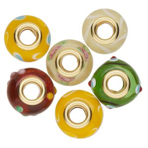 Bead, Dione®, lampworked glass and gold-finished brass grommets, transparent yellow and opaque multicolored, 12x8mm-16x9mm rondelle with assorted designs. Sold per pkg of 6.