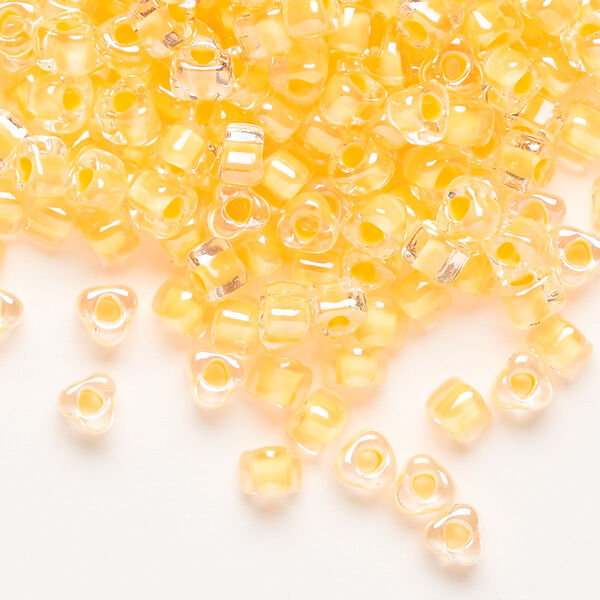 Seed bead, Miyuki, glass, transparent clear color-lined yellow, (TR1121), #5 triangle. Sold per 25-gram pkg. image number 0