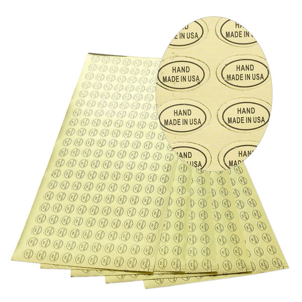 Adhesive label, paper, gold and black, 1/2 x 5/16 inch oval with "HAND MADE IN USA." Sold per pkg of 1,000. image number 0