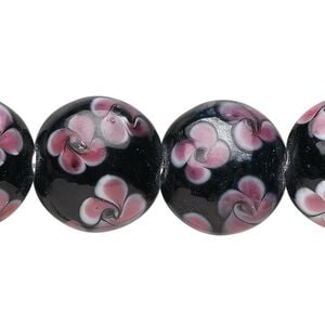 Bead, glass, opaque black and pink, 19x10mm puffed flat round with flowers design. Sold per 15-1/2" to 16" strand.