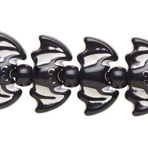 Bead, acrylic, black and white, 7x5.5mm crow and 23x13mm bat. Sold per 7-inch strand.