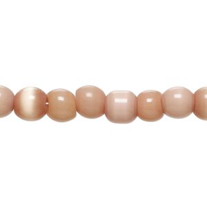 Bead, cat's eye glass (fiber optic glass), light peach, 5-8mm irregular round. Sold per 14-inch strand, approximately 60 beads.