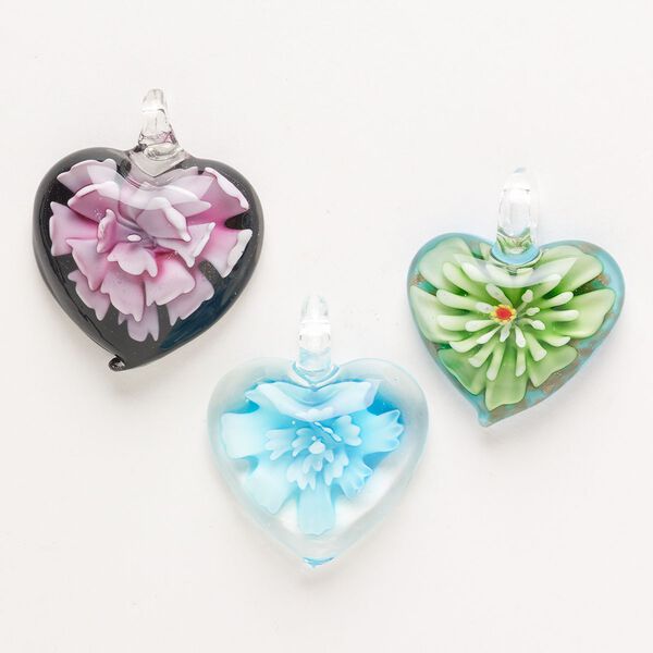 Random focal mix, lampworked glass, pkg/3, opaque to transparent mixed colors with silver-colored foil and copper-colored glitter, 34x30mm-40x36mm puffed heart with flower. image number 0
