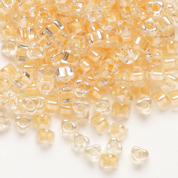 Seed bead, Miyuki, glass, transparent clear color-lined tawny, (TR1131), #5 triangle. Sold per 250-gram pkg. image number 0